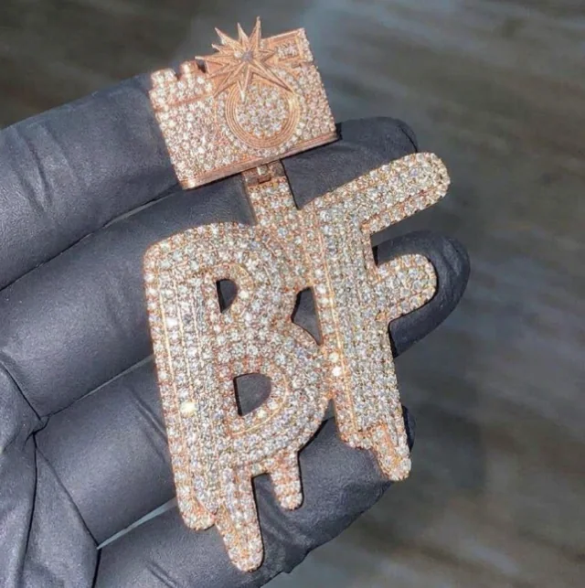 Custom rose gold diamond initials pendant held in a jewelry glove